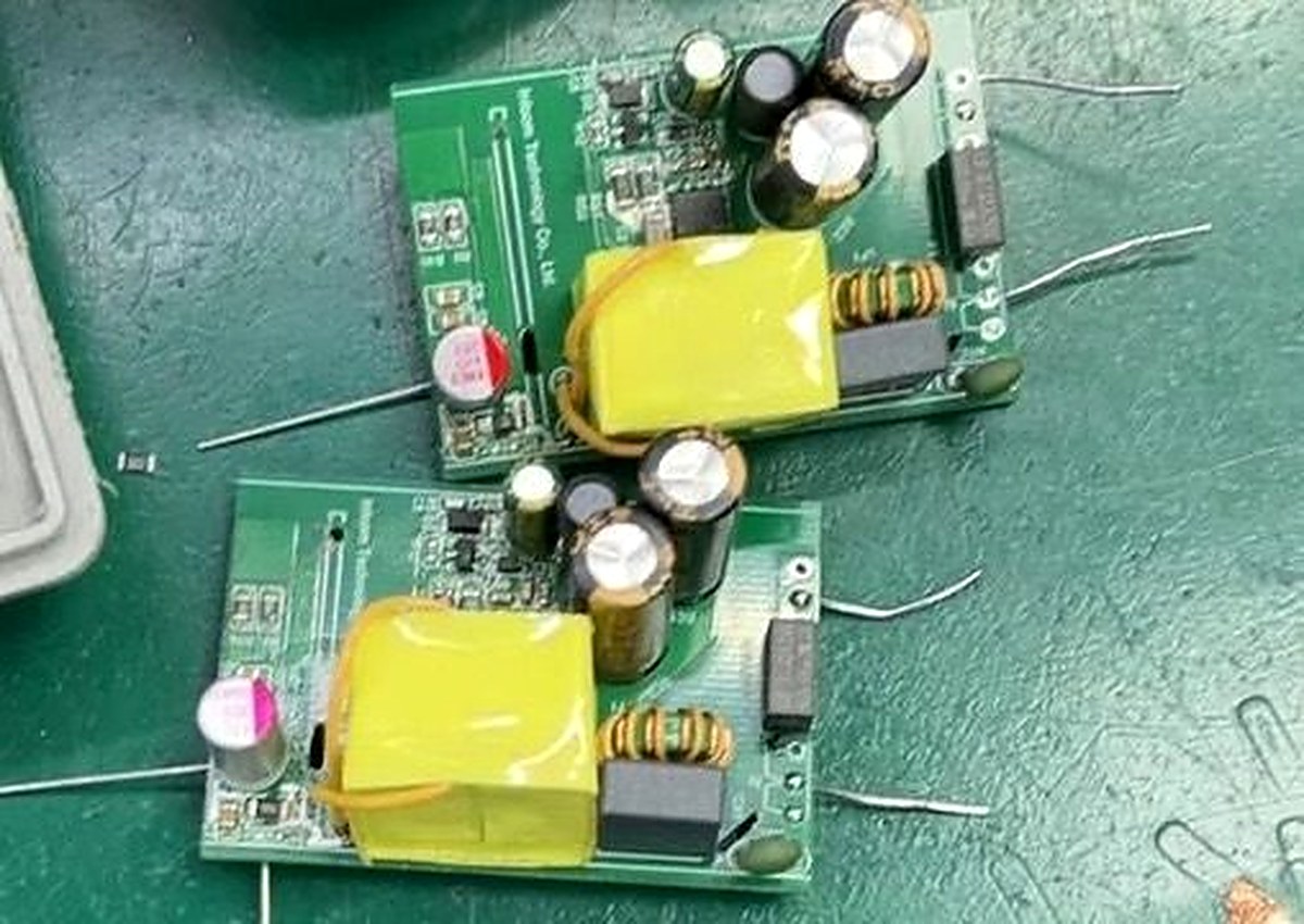 Charlie Charger power supply PCBs on factory workbench — production samples with transformers and capacitors