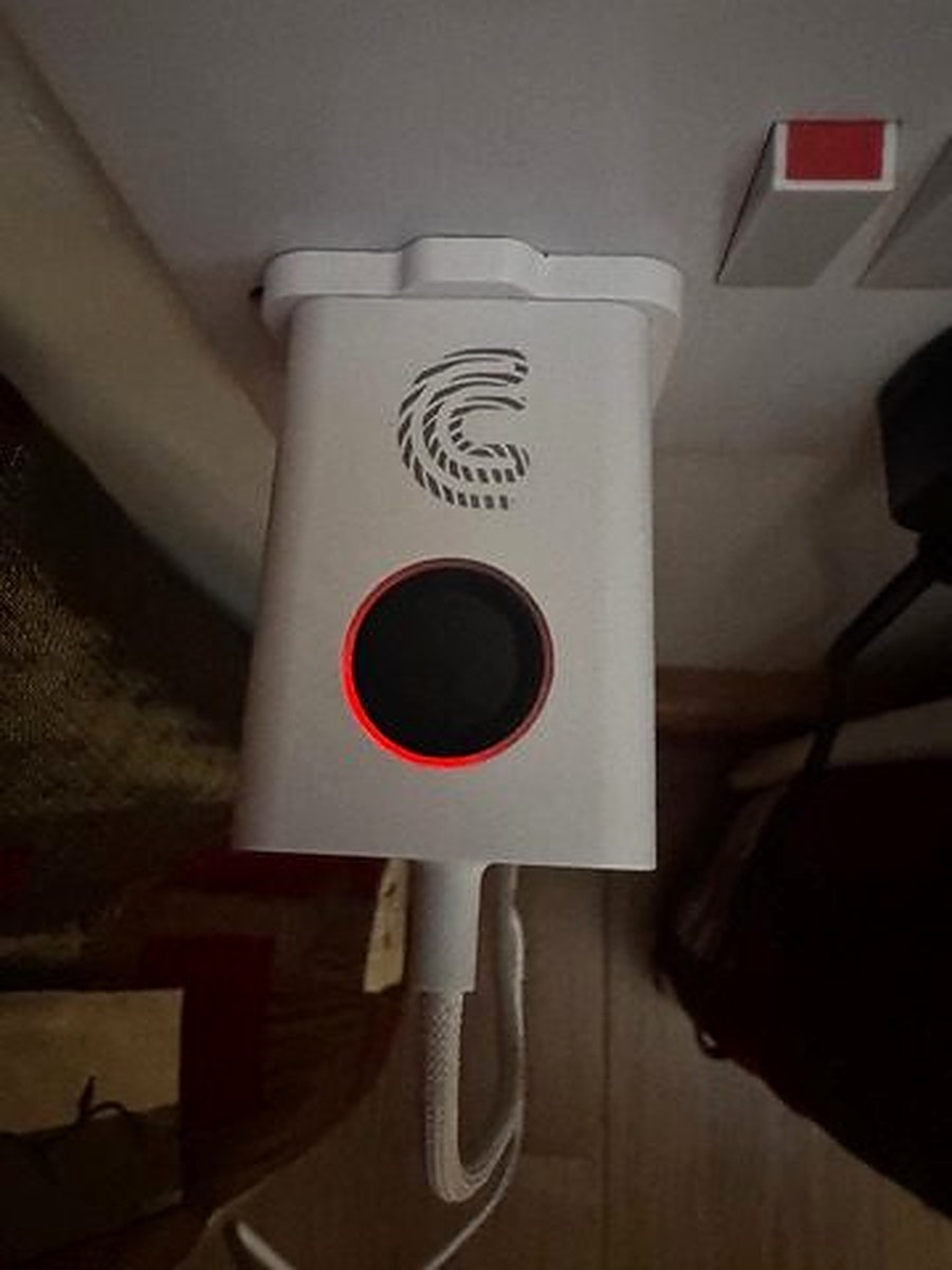 Charlie Charger plugged into wall socket showing red LED ring around fingerprint sensor