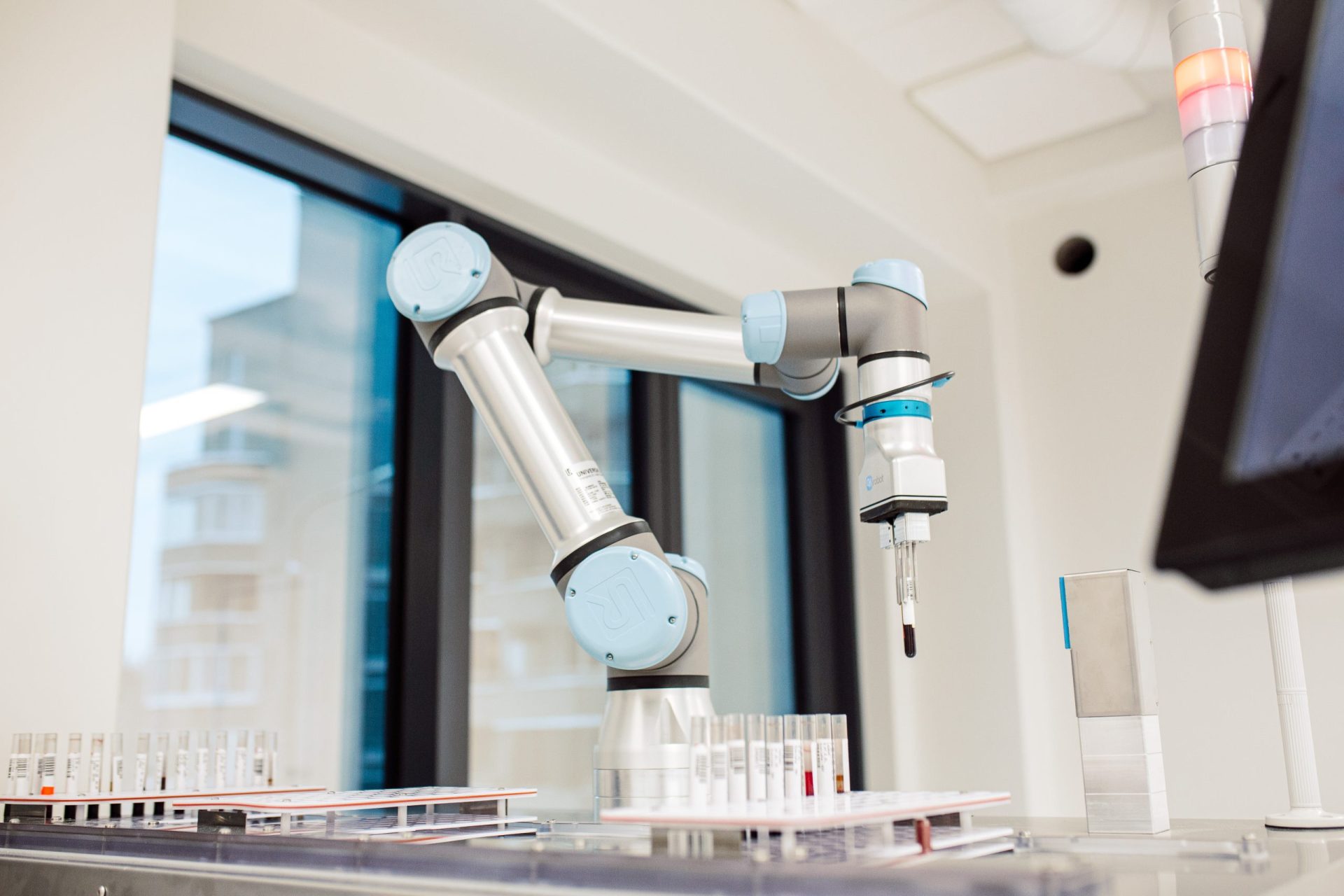 NOVAFlex station — cobot arm gripping a sample tube