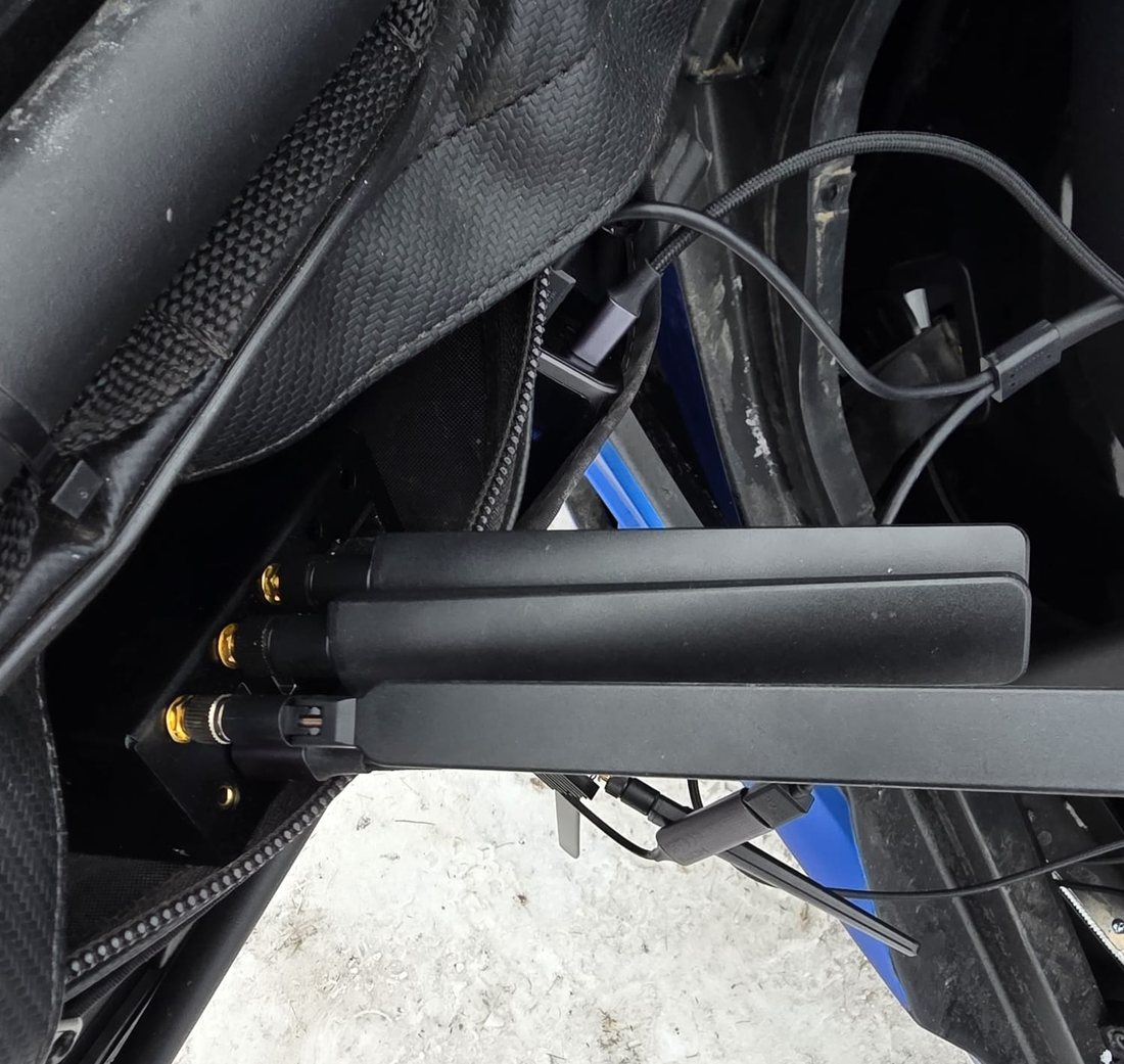 Three paddle antennas on gold SMA connectors on a field unit inside a competition car, with USB cabling